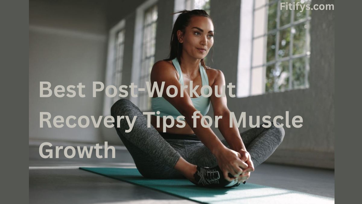 A female model is sitting on a yoga mat in a butterfly stretch pose, looking up and to the right with a serene expression. The text overlay reads "Best Post-Workout Recovery Tips for Muscle Growth." In the upper right corner, the website "Fitifys.com" is visible. The background is blurred, showing large windows.
